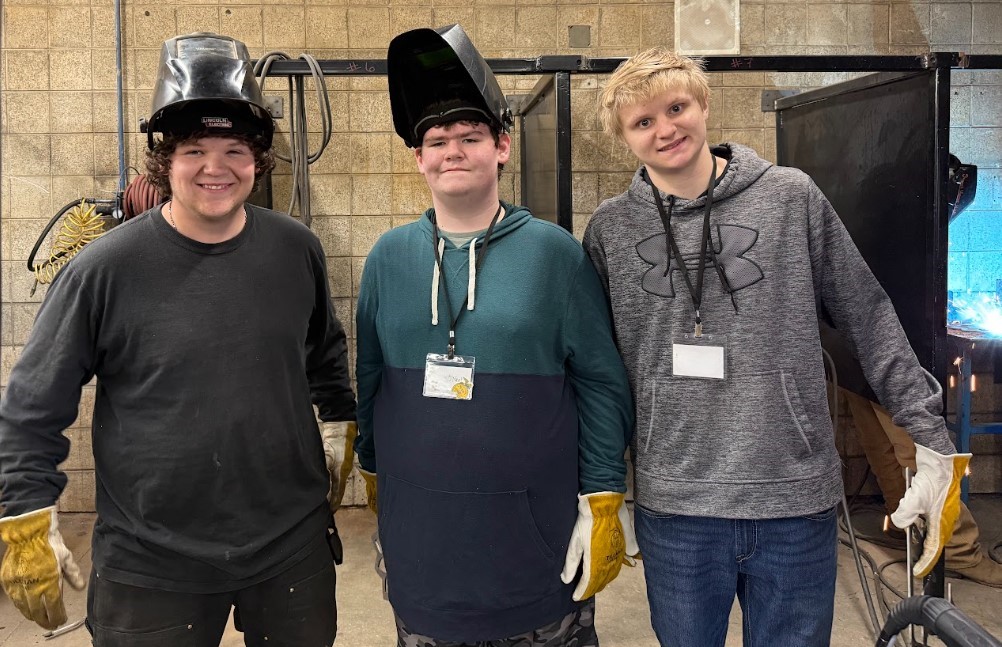 3 metal shop students standing next to each other