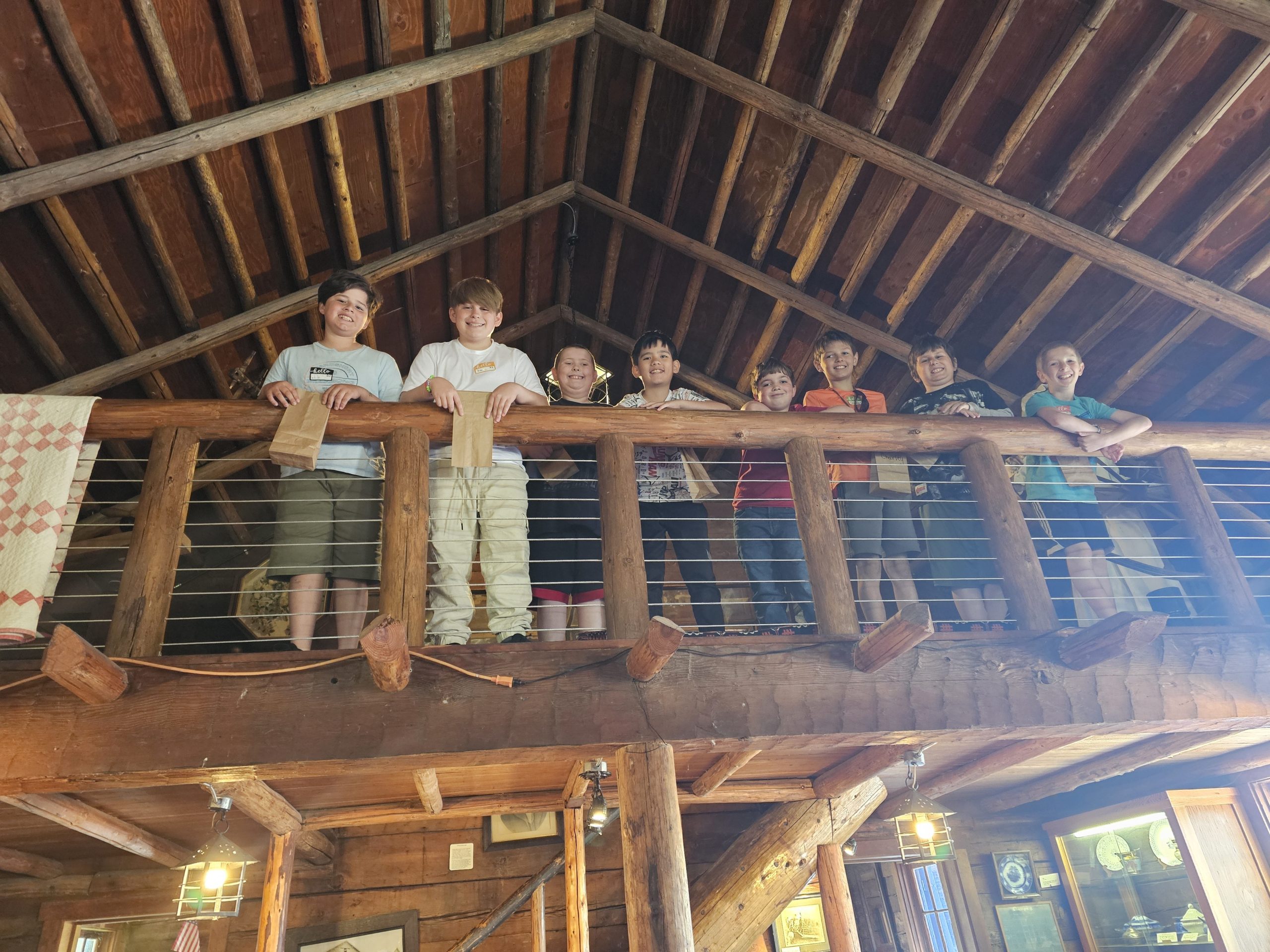 students standing next to each other in the second floor of a cabin.